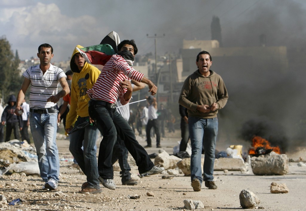 Palestinian youths throw stones during protest in Baqa Ash-Sharqiya